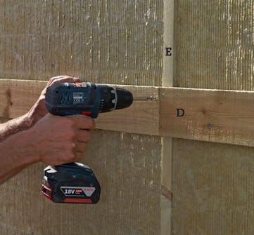 Støjhegn: Skru brædder (D) fast uden på isoleringen med to 4,5 x 60 mm skruer i hver stolpe. Støjhegn: Skru brædder (D) fast uden på isoleringen med to 4,5 x 60 mm skruer i hver stolpe.